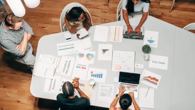 Equipo de marketing revisando la estrategia y los gráficos de una campaña sobre una mesa